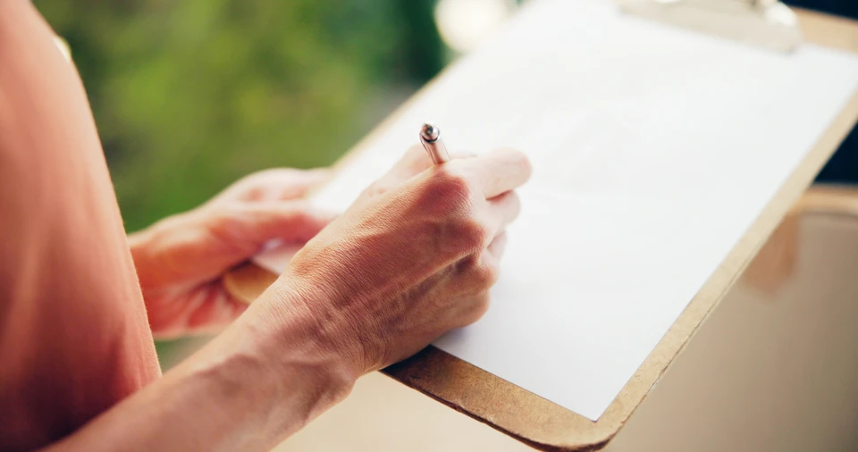 Scène extérieure de jardin avec professionnel en salopette et casquette orange consultant une tablette numérique